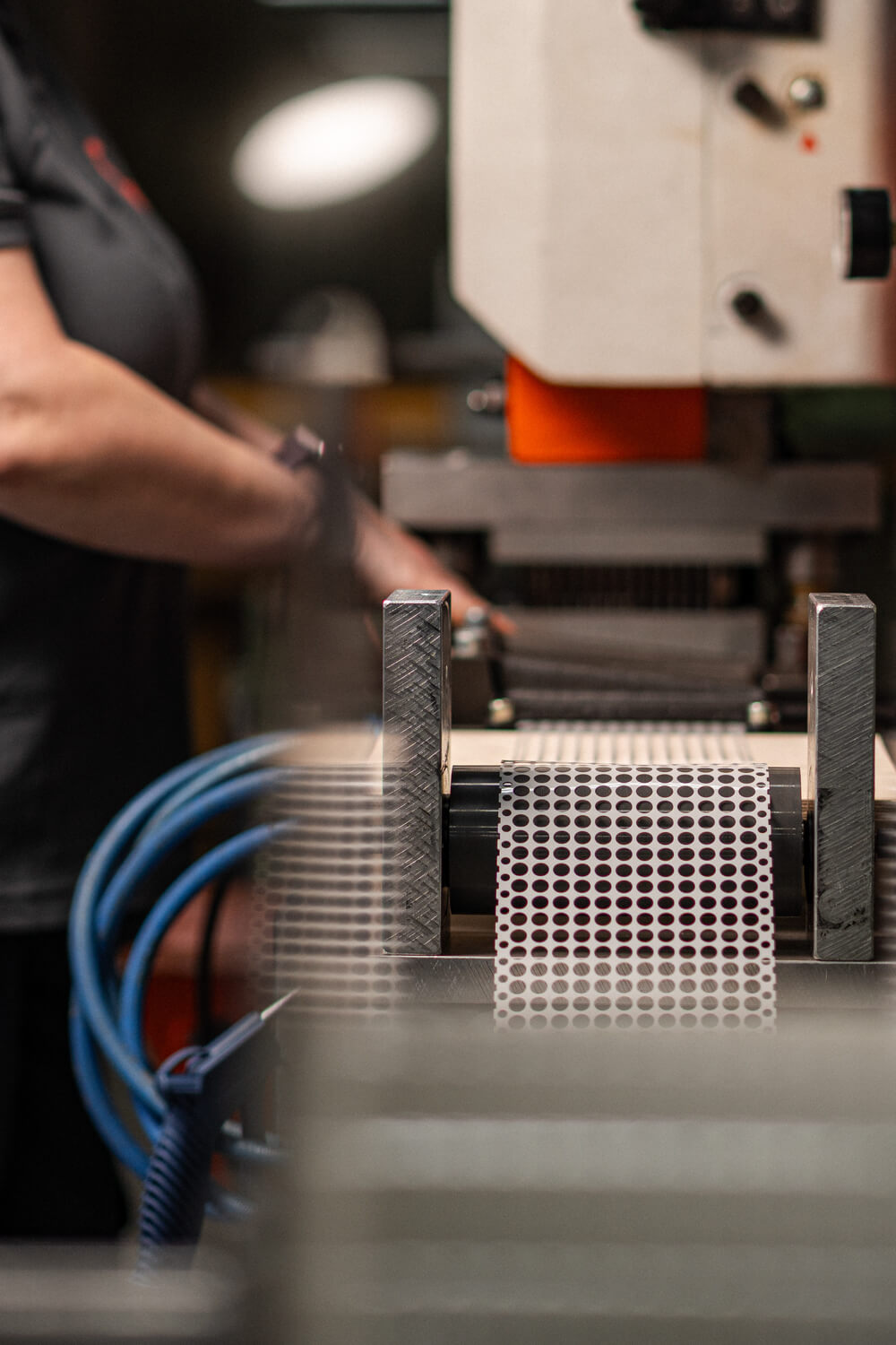 Nahaufnahme der Hände eines Mitarbeiters, der ein präzises Stanzwerkzeug für die Serienproduktion technischer Stanzteile bei Grashorn einrichtet.